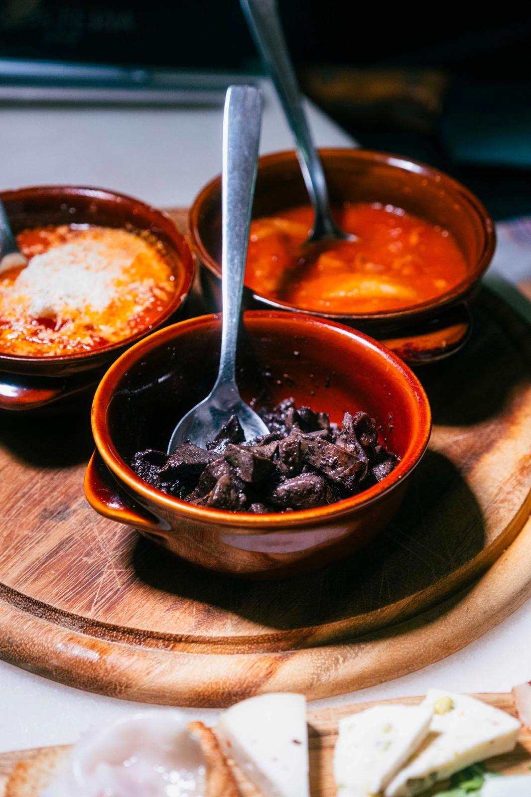 Tris di antipasti romani serviti in ciotole di terracotta